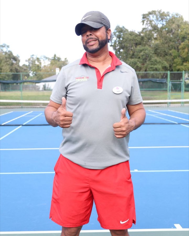 Coach John Richards III giving two thumbs up on court
