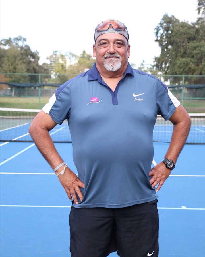 Coach Junior Gonzalez standing on court with hands on hips